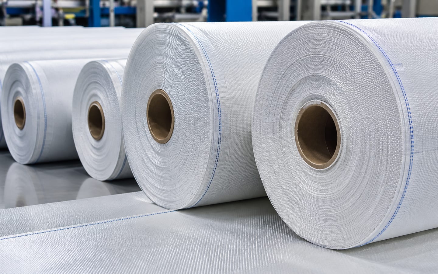 Rolls of woven filtration fabric, blue selvedge stripe running the length of each roll